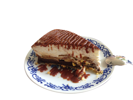 piece of banoffee cake with chocolate fudge on isolated backgroundの写真素材