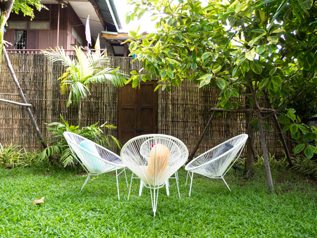 sitting area in the shady garden with pavement and treesの写真素材