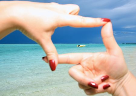 Woman framing the horizon on sea with hands, closeupの写真素材