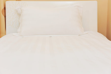 Single bed in luxurious hotel room.の写真素材