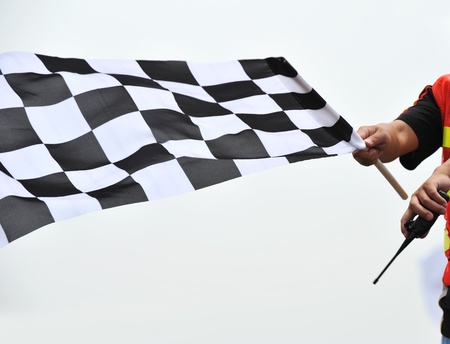 checkered race flag in hand.の写真素材