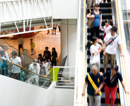 People in motion in escalators at the modern shopping mall. 