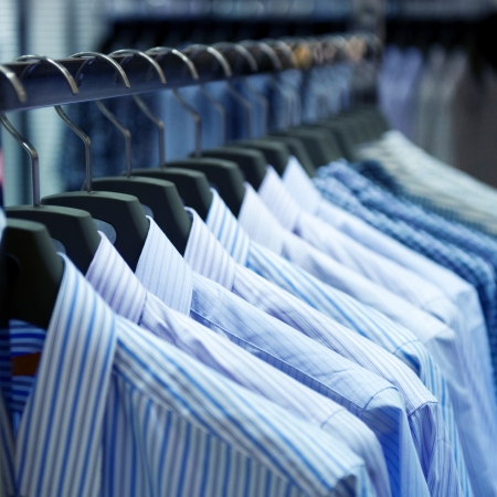 row of cloth hangers with shirts の写真素材