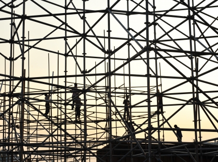 Construction workers working on scaffoldingの写真素材