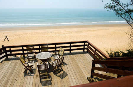 Six chairs and table by the beach shore.のeditorial素材