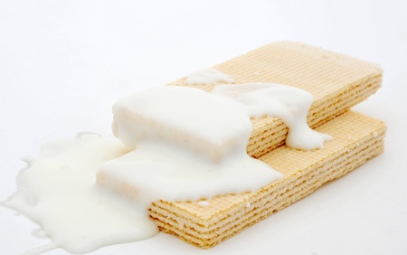 Lots of white chocolate falling to the wafer biscuits.の写真素材