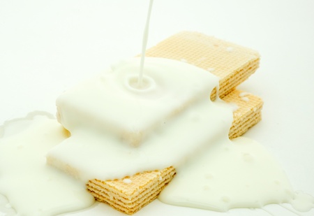 Lots of white chocolate falling from above to the wafer biscuits.の写真素材