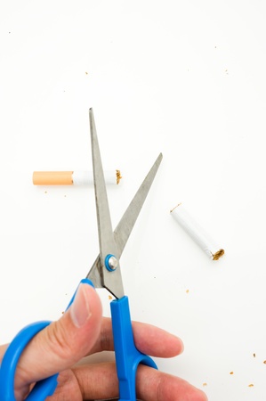 A hand cutting cigarette, quit smoking.の写真素材