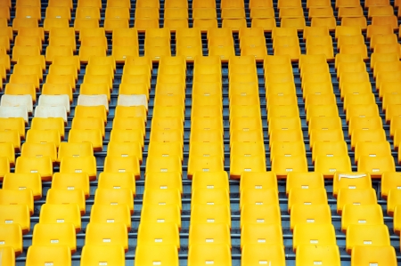 Rows of yellow football stadium seats with numbers.の写真素材