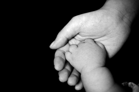 New-born baby hand in mother's palm, isolated on black background.
の写真素材