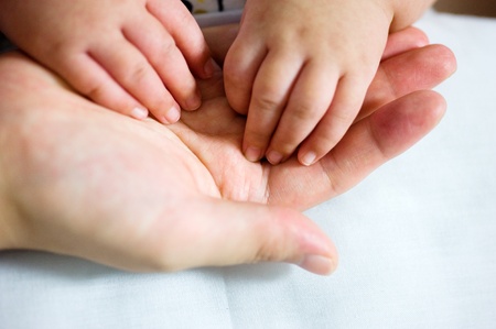 New-born asian baby hand in father's palm.の写真素材