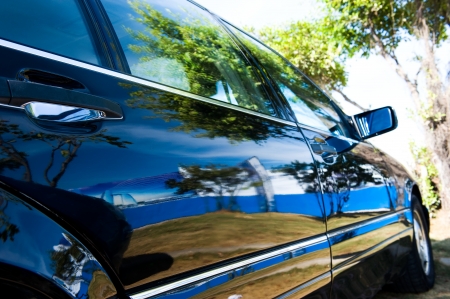 A well polished sedan reflecting beautiful scene,  trees and blue sky.
の写真素材