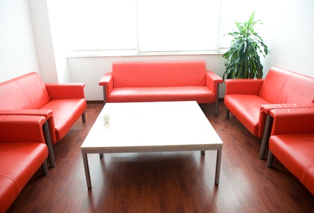 Red leather sofa and white table at waiting room.のeditorial素材