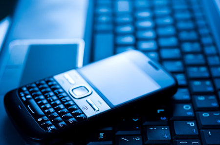 laptop and cellphone, business communication concept. Macro with extremely shallow depth of field