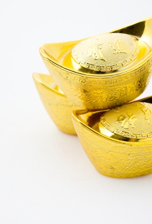 Chinese gold ingot ornaments isolated on white background. The characters on gold ingot means "Making plenty of money" 
の写真素材