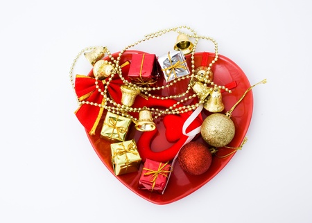 Christmas presents with colorful packages and christmas bells on a heart shape plate.
 の写真素材
