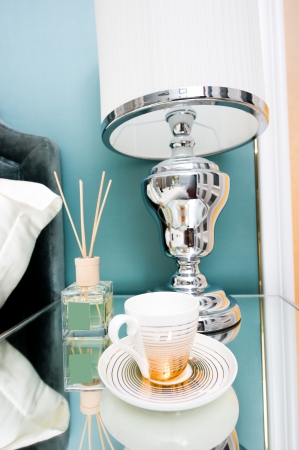 Detail of bed and bedside table with lamp and cup in a hotel room. 
の写真素材
