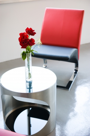 Table and chairs with a red rose vase. の写真素材