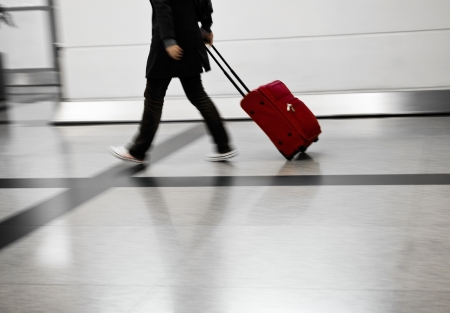 
Man with red bags rushing at the airportの写真素材