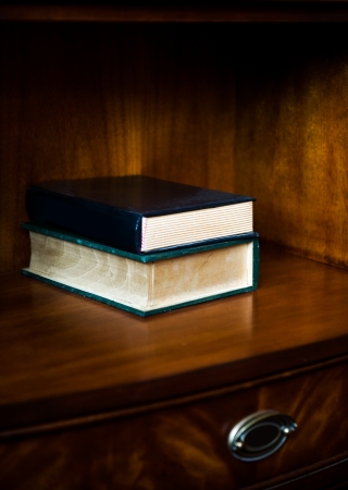 Two antique books stacked on table.の写真素材