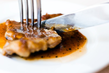 cutting a steak with knife and forkの写真素材