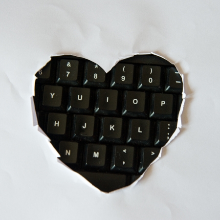 Heart shape hole through white paper. の写真素材