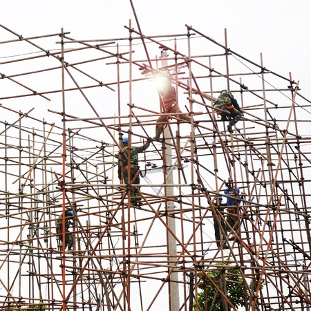Construction workers working on scaffolding の写真素材