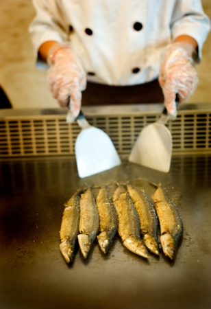 Japanese chef cooking traditional saury teppanyaki on a hot plate. の写真素材