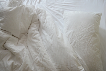 close up of messy bedding sheets and pillow の写真素材
