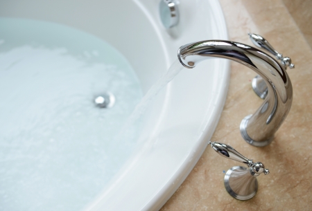 Luxury bath tub and faucet with water. の写真素材