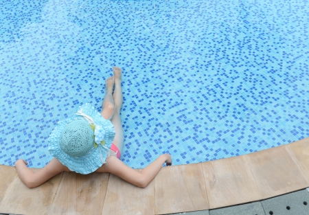 woman enjoying a swimming pool in a large sunhat の写真素材