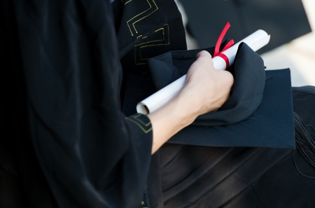 people in a gown holding a diploma.の写真素材
