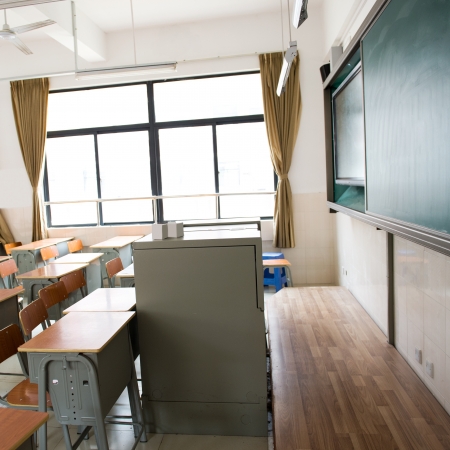 Empty classroom with chairs, desks and chalkboard.の写真素材