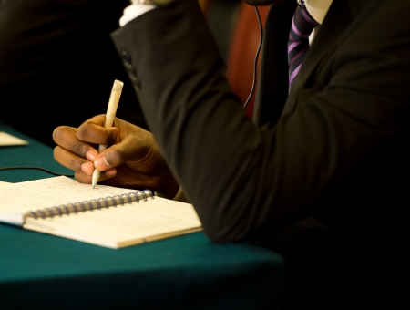 Closeup of human hand writing on a paper.の写真素材