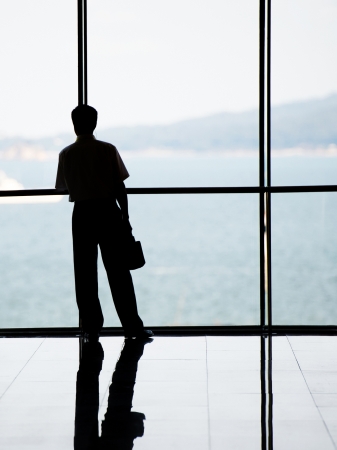 Profile of business people against the windows in an office tower.の写真素材
