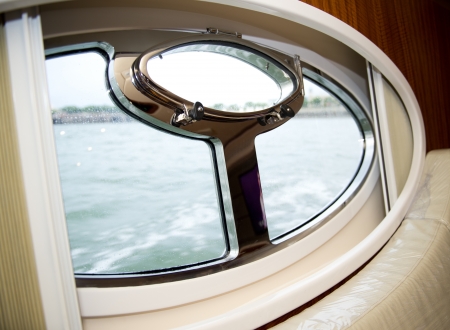 Close-up of a yacht closed porthole with ocean viewの写真素材