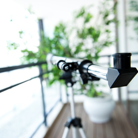 A telescope setting near the window.の写真素材