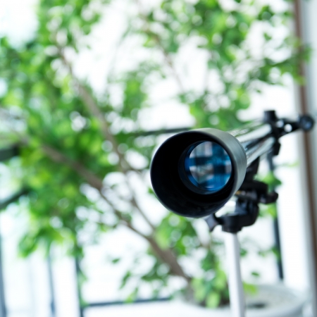 A telescope setting near the window.の写真素材
