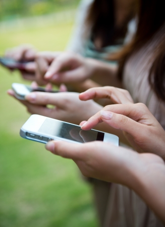 closeup of three people using smart phone.の写真素材
