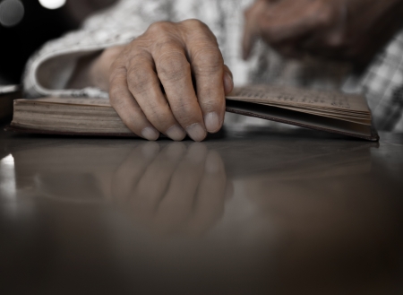 Old man holds a bible in his hands.の写真素材