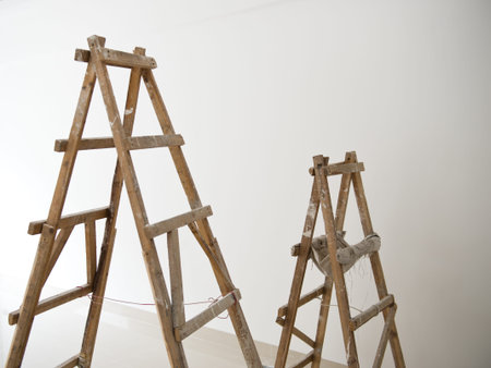 Two wood ladders in front of white wall for home improve.の写真素材