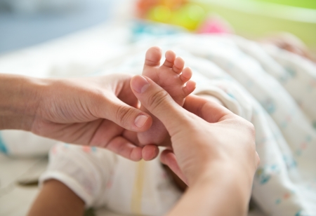 Masseur massaging little baby's foot.の写真素材