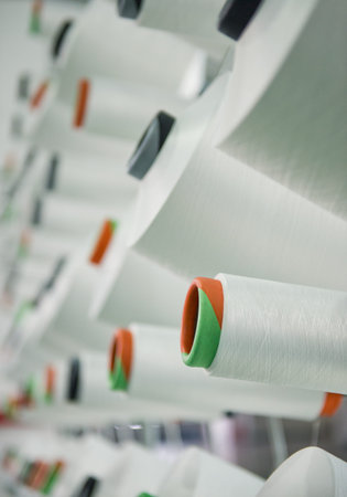 Textile industry - yarn spools on spinning machine in a textile factory