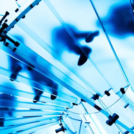 Silhouette people on glass staircaseの写真素材