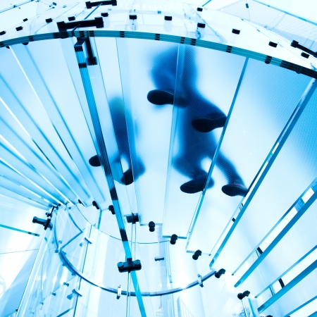 Silhouette people on glass staircaseの写真素材