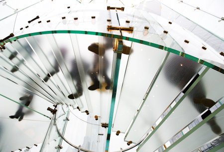 Silhouette people on glass staircaseの写真素材