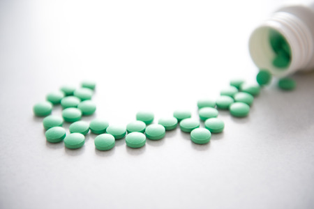 Many pills spilling out of pill bottle.の写真素材