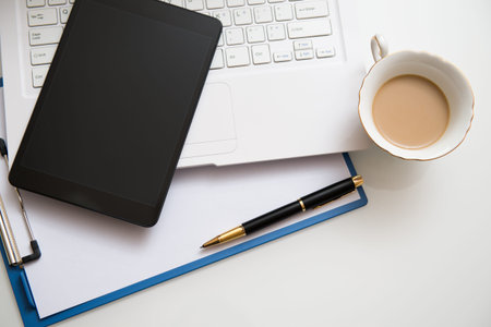 Modern workplace with digital tablet, pen and papers.