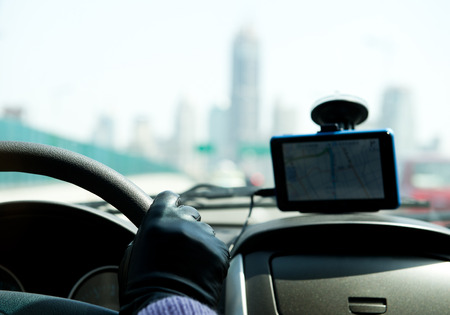 Female driver's hands on steering wheel inside of a car, using a satelite navigation/GPS.
の写真素材