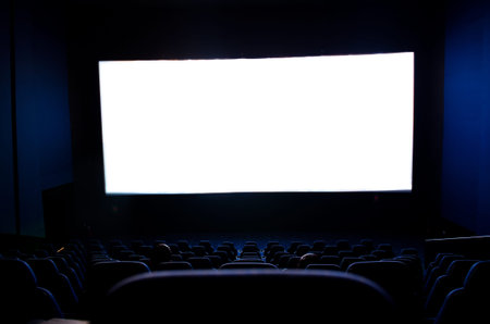Dark movie theatre interior. screen and chairs.